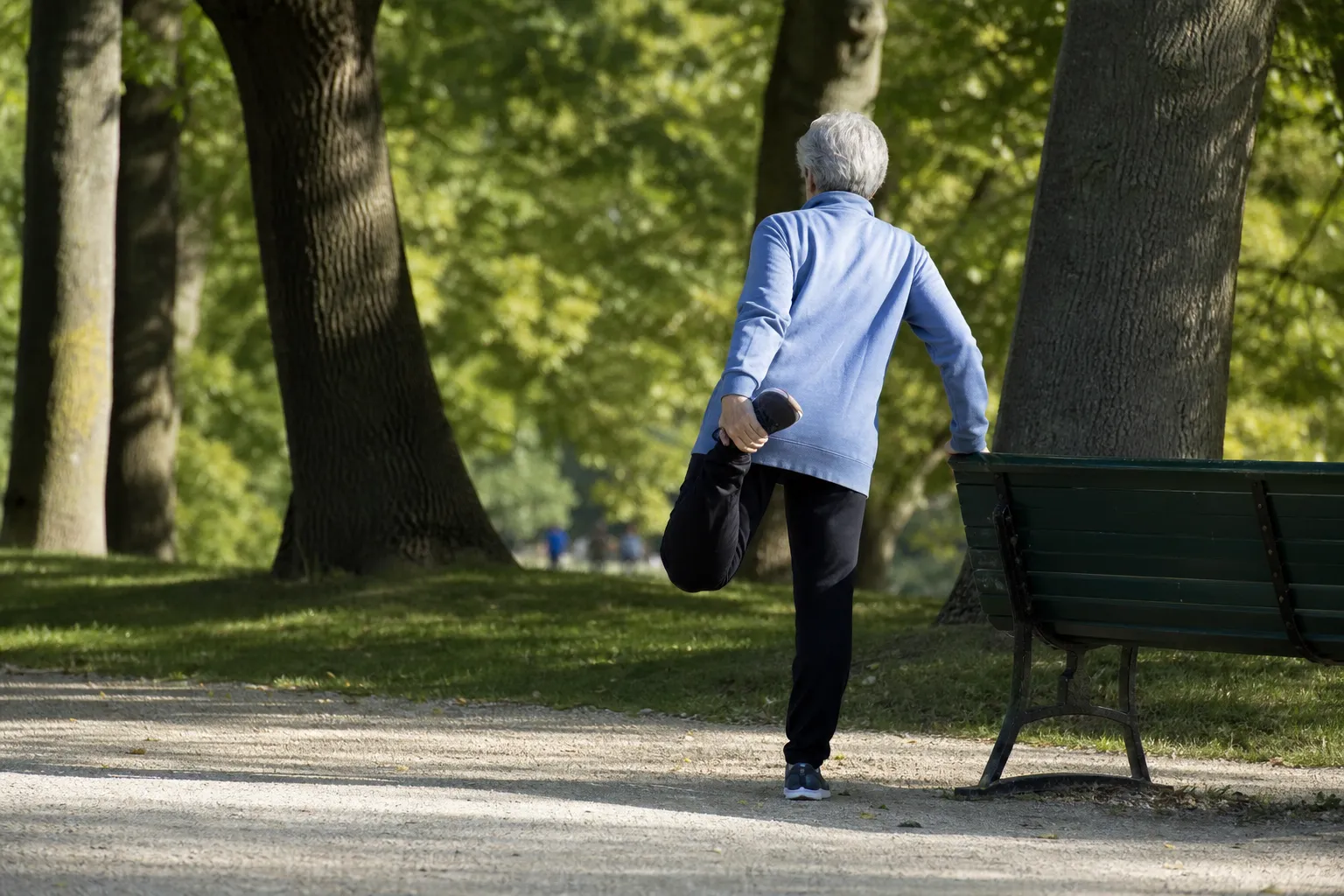 Personne senior en marche active dans un parc, allure posée